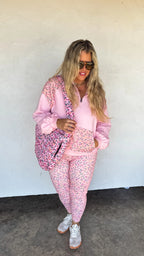 Woman wearing a pink floral outfit with a white background